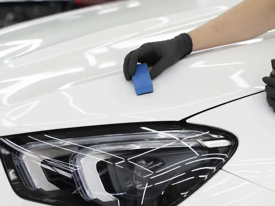 Ceramic coating being applied by hand to the bonnet of a white car